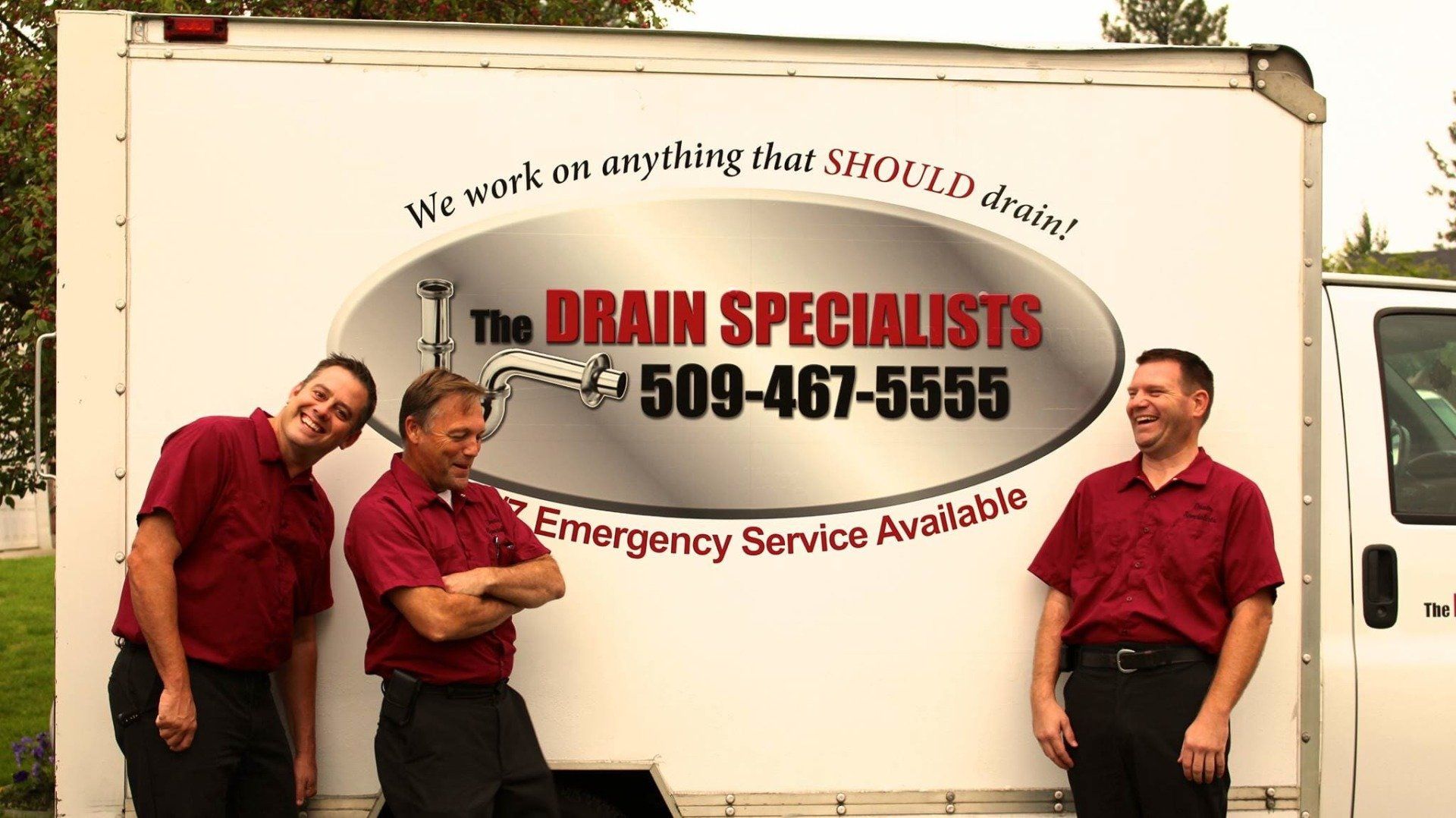 Plumbers standing beside service truck